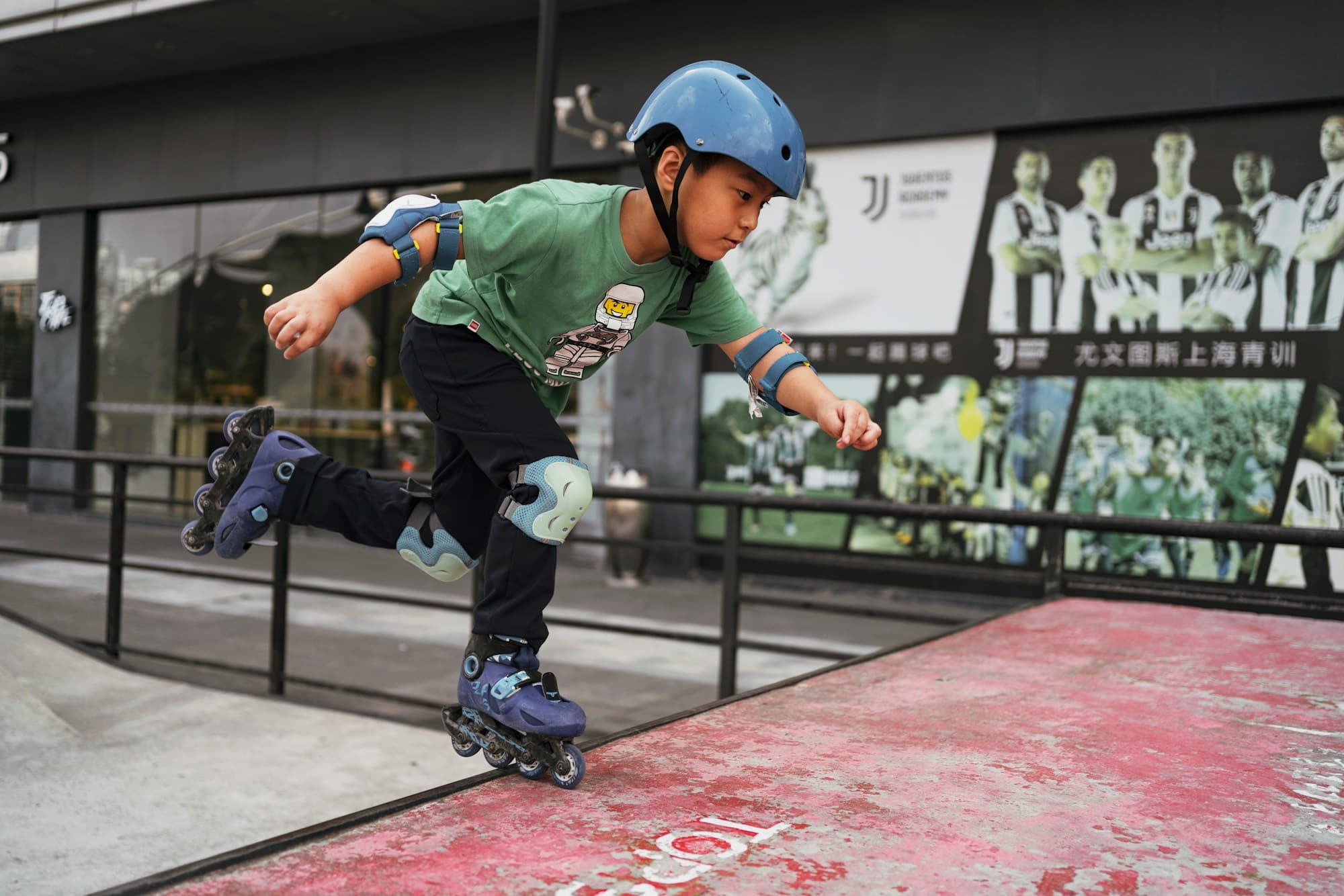 A young skater in helmet and pads striding on inline skates